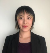 Image of a professionally dressed person with a short black and blonde bob smiling.